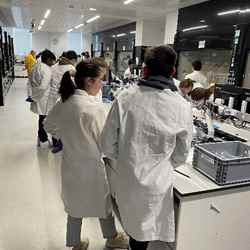 Students in white coats work in a laboratory