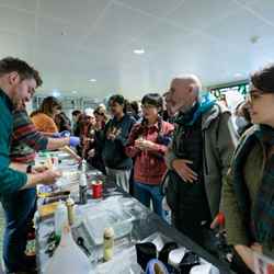 A man speaks with visitors to the Bitesized Soft Matter stand at the Imperial Lates event