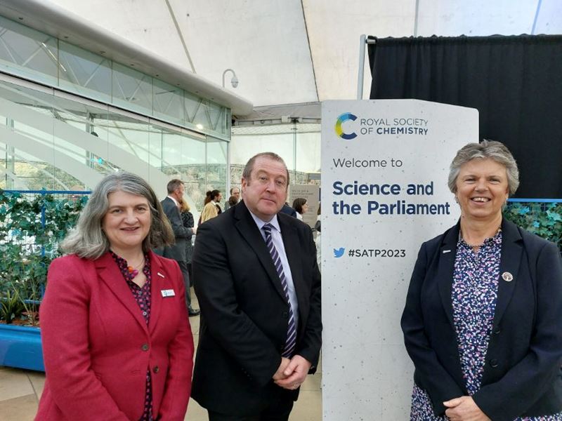 RSC chief executive Dr Helen Pain, Scottish Minister for Higher and Further Education Graeme Dey MSP, and RSC president Professor Gill Reid stand in front of an RSC banner that says 'Science and the Parliament' inside Our Dynamic Earth in Edinburgh, Scotland