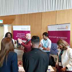 Several programme participants visit the stall of AstraZeneca