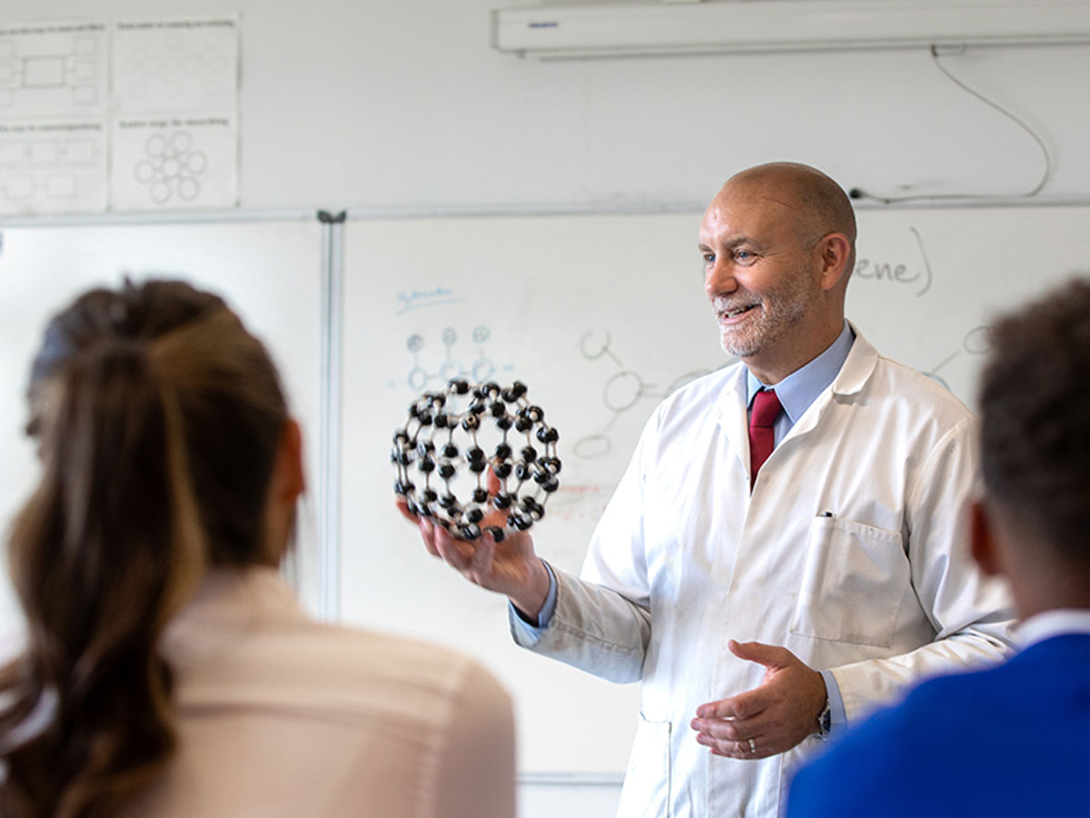 Teacher with atom ball and students